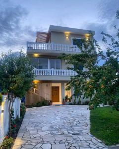 uma casa com uma entrada de pedra em frente em Villa Kanto (Holiday apartments and rooms) em Vlorë