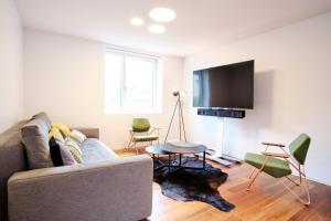 uma sala de estar com um sofá e uma televisão de ecrã plano em Les Cubes em Martigny-Ville