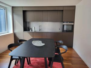 a black table and chairs in a kitchen at Les Cubes in Martigny-Ville