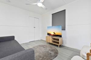 ein Wohnzimmer mit einem Sofa und einem Flachbild-TV in der Unterkunft Moreton Views! in Beachmere