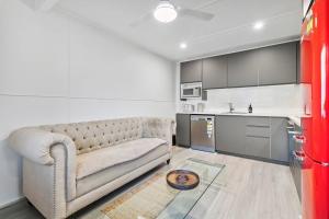ein Wohnzimmer mit einem Sofa und einer Küche in der Unterkunft Moreton Views! in Beachmere