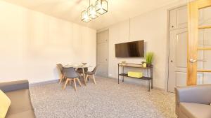 uma sala de estar com uma mesa e cadeiras e uma televisão em Host & Stay - Millbank Crescent Apartments em Bedlington