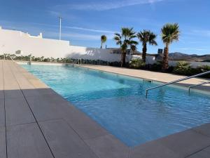 una gran piscina con palmeras y un edificio en Casa del Mar, en San José