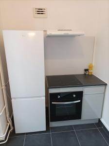 a kitchen with a white refrigerator and a stove at O'Couvent - Appartement 85 m2 - 2 chambres - A522 in Salins-les-Bains