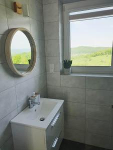 W łazience znajduje się biała umywalka i lustro. w obiekcie Zasankowe Wzgórze w mieście Zasań