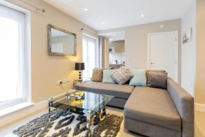 a living room with a couch and a table at Velvet 2-bedroom apartment, Conduit Lane, Hoddesdon in Hoddesdon