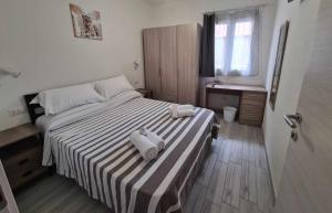 Un dormitorio con una cama con dos toallas encima. en Civico 14 Apartment 01, en Monserrato