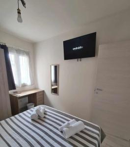 een slaapkamer met een bed en een televisie aan de muur bij Civico 14 Apartment 01 in Monserrato