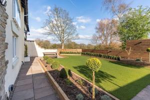 a garden with a bench in the middle of a yard at 1 The Cottage in Upholland