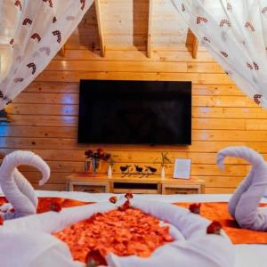 a bedroom with a bed with a flat screen tv at DSR Wooden Cottages in Hyderabad