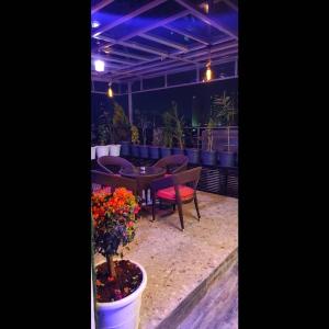 a patio with a table and chairs and flowers at DSR Wooden Cottages in Hyderabad