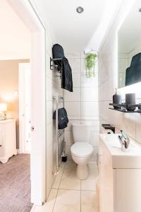 a white bathroom with a toilet and a sink at 1 The Cottage in Upholland