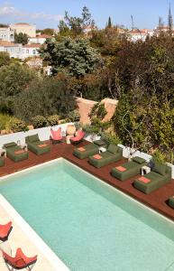 a swimming pool with chaises and chairs next to at Yayaki Spetses in Spetses