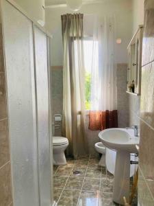 ein Bad mit einem Waschbecken, einem WC und einem Fenster in der Unterkunft “La Lavanda” in Maremma in Ischia di Castro