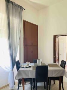 ein Esszimmer mit einem Tisch, Stühlen und einem Fenster in der Unterkunft “La Lavanda” in Maremma in Ischia di Castro
