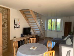 a living room with a table and a staircase at Appartement T3 lumineux 70m² in Brest