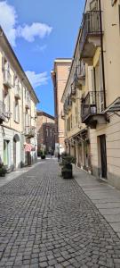 a cobblestone street in a town with buildings at Ca' Balenga - Centralissimo con posto auto coperto gratuito in Asti
