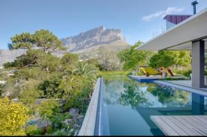 a house with a swimming pool with a mountain in the background at Blair Atholl Estate in Lanseria