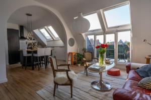 ein Wohnzimmer mit einem Sofa und einem Tisch mit Blumen darauf in der Unterkunft Hyper Centre Tours - Charmant Balcon in Tours