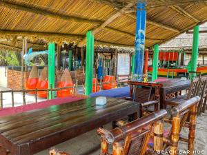 un pabellón con 2 bancos de madera y una mesa en Beach Bar Hue Hostel, en Hue
