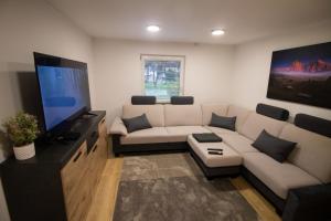 a living room with a couch and a flat screen tv at GREEN LAND Family Fun Sport Resort in Šmarje pri Jelšah