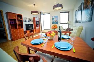 格地尼亞的住宿－豪華洛克菲勒海洋大廈公寓，一张带蓝盘和一瓶葡萄酒的餐桌
