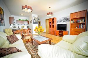 格地尼亞的住宿－豪華洛克菲勒海洋大廈公寓，客厅配有2张白色沙发和1张桌子