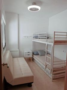 a room with two bunk beds and a couch at Moderno apartamento en Oliva Nova golf & MET in Oliva
