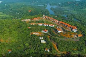an aerial view of a house on a hill next to a river at Niraamaya Retreats Vaidekam, Kannur in Kannur