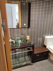 a bathroom with a glass sink and a mirror at Moderno apartamento en Oliva Nova golf & MET in Oliva