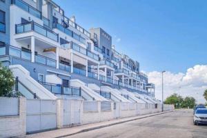 a large building with a car parked in front of it at Moderno apartamento en Oliva Nova golf & MET in Oliva