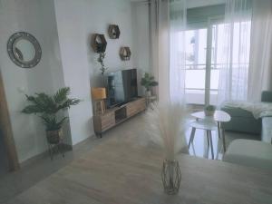 a living room with a flat screen tv and a table at Moderno apartamento en Oliva Nova golf & MET in Oliva