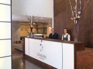 a man and a woman standing behind a reception desk at Spark Hoteles in Antofagasta