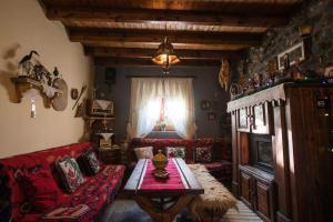 a living room with a couch and a table and a bed at Vila118 in Voskopojë