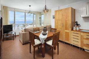 a kitchen and living room with a table and a couch at Las Terrazas Primera Línea de playa in Mezquitilla