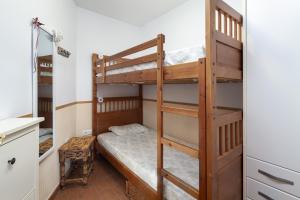 a bedroom with a bunk bed with a ladder at Las Terrazas Primera Línea de playa in Mezquitilla +11 photos