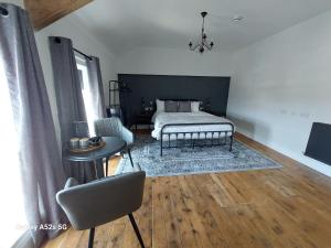 a bedroom with a bed and a table and a chair at LONDONDERRYS Bar and Accommodation in Seaham