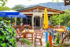 a restaurant with tables and chairs and an umbrella at Sunrise Bungalows in Cıralı