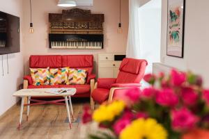 a living room with two red chairs and a table at Bökény-vendégház in Sümeg