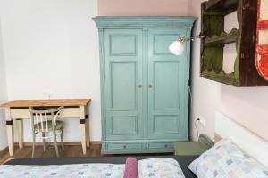 a blue cabinet in a room with a desk at Bökény-vendégház in Sümeg