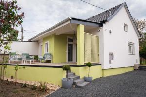 ein Haus mit einer gelben und weißen Fassade in der Unterkunft Bökény-vendégház in Sümeg