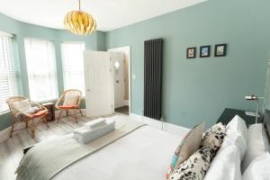 a bedroom with a large bed with blue walls at Sunbeam Cottage in Whitstable