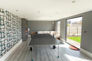 a ping pong table in a room with a couch at Sunbeam Cottage sleeps 10 in Whitstable