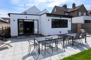 a patio with a table and chairs in front of a house at Sunbeam Cottage sleeps 10 in Whitstable