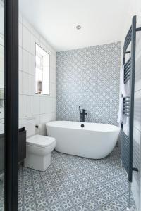 a bathroom with a white tub and a toilet at Sunbeam Cottage sleeps 10 in Whitstable +32 photos