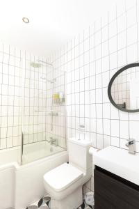 a bathroom with a toilet and a tub and a sink at Sundance Cosy Getaway - Annexe in Whitstable