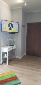 Pokój z biurkiem i telewizorem na ścianie w obiekcie Uroczy Apartament Happy 01 z widokowym tarasen na dachu - tuż przy plaży !!! w mieście Niechorze +17 zdjęć