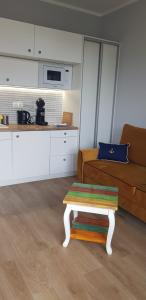 salon ze stołem i kanapą w obiekcie Uroczy Apartament Happy 01 z widokowym tarasen na dachu - tuż przy plaży !!! w mieście Niechorze