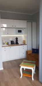 kuchnia i salon z ławą i stołem w obiekcie Uroczy Apartament Happy 01 z widokowym tarasen na dachu - tuż przy plaży !!! w mieście Niechorze