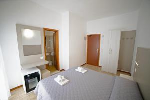 una camera da letto con un letto con due asciugamani bianchi di Hotel Ischia a Rimini